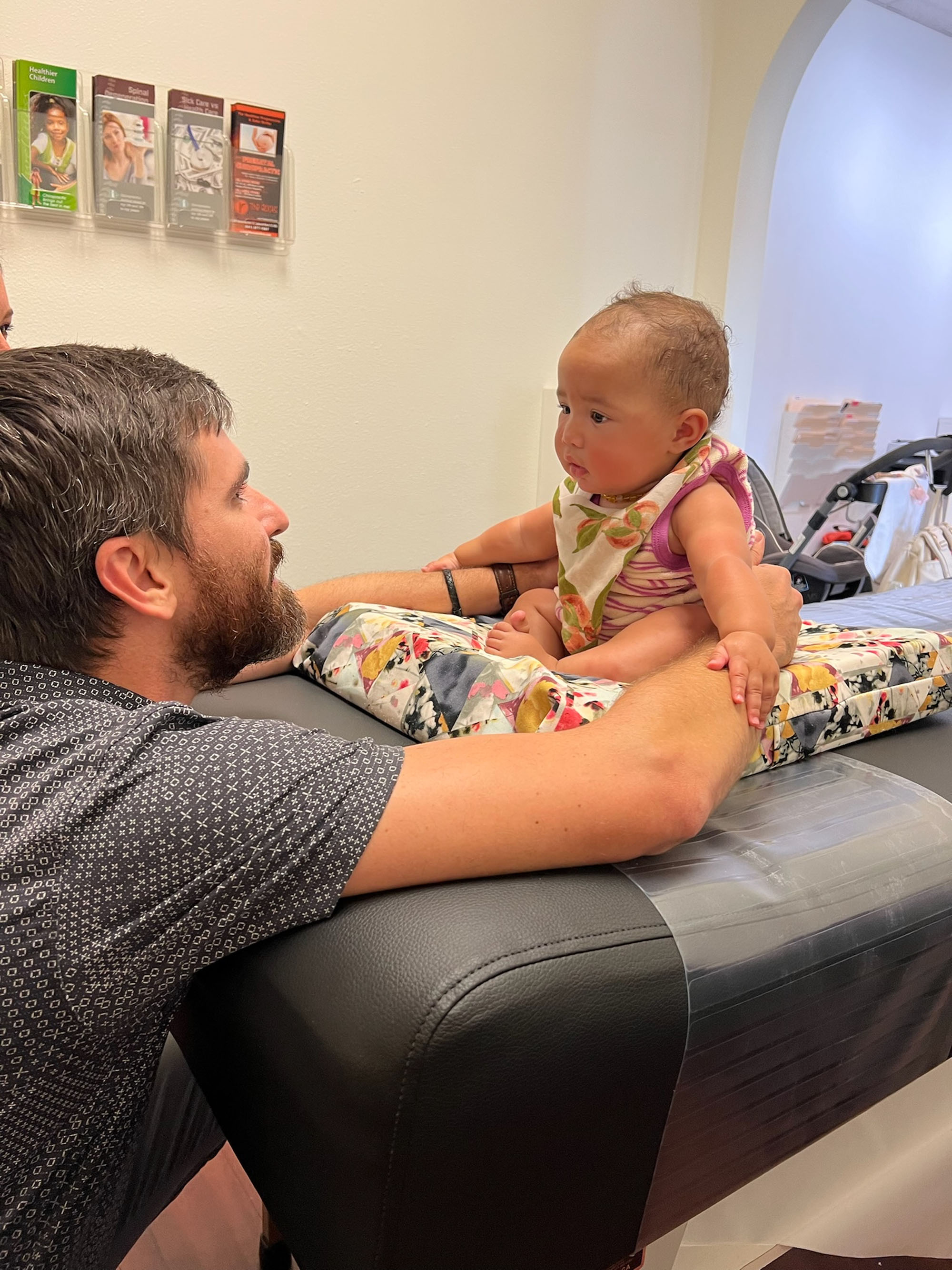Dr. Logan Swaim makes gentle eye contact with an infant during a visit.